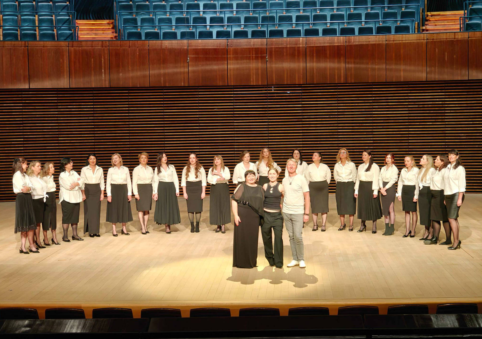 Photo of VOLA Default standing on the scene with a choir behind her